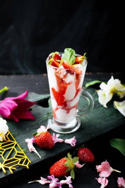 Dondurma ve dilim od çilek ile cam, çiçek ve meyve ile masada dekore nane leavs