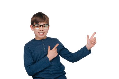 Beyaz duvar üzerinde kamera bakarak serin küçük çocuk uzağa işaret ediyor 