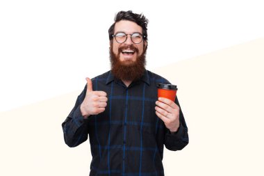 Kahve var. Mutlu adam onaylıyor ve başparmak gösteren. Sakallı 