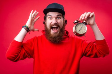Sakallı adam n hoody Fotoğraf, bir vintage saat tutan ve onun toplantıda gecikme hakkında sinirli