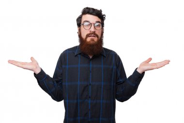 Yakışıklı, sakallı bir adamın fotoğrafı, bilinmeyen bir jest yapıyor, beyaz arka plan üzerinden kameraya bakıyor 