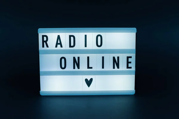 Photo of a light box with text, RADIO ONLINE, dark isolated background