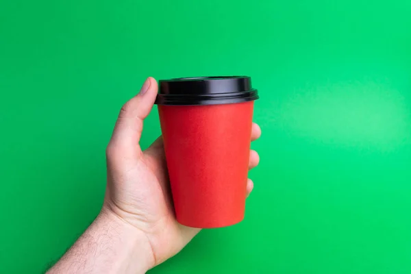 Une Main Tenant Une Tasse Emporter Rouge Sur Fond Vert — Photo