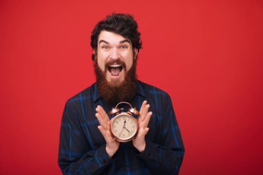 Sakallı adamın fotoğrafı çalışmaya hazır. Çalışma zamanı. Kırmızı izole arka plan 