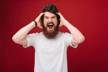 Yakışıklı kızgın umutsuz Closeup portre, kırmızı arka plan üzerinde sinirli sakallı adam vurguladı 