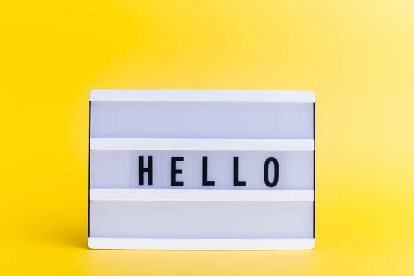 Photo of a light box with text, HELLO, on isolated yellow background