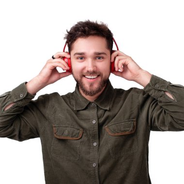 Kulaklıkla müzik dinleyen ve kameraya bakan genç adamın fotoğrafı, izole arka plan