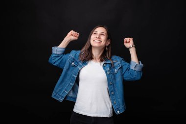 Mutlu güzel genç kadın elleri yukarı ve gülümseyerek başarı kutluyor