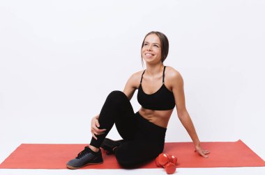 Kırmızı yoga mat ayakta neşeli spor kadın fotoğraf ve uzak bakıyor