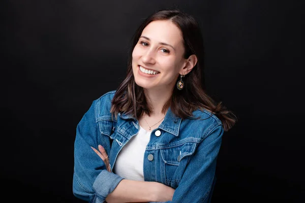 Retrato interior de una hermosa mujer sonriente de pie sobre un fondo oscuro — Foto de Stock