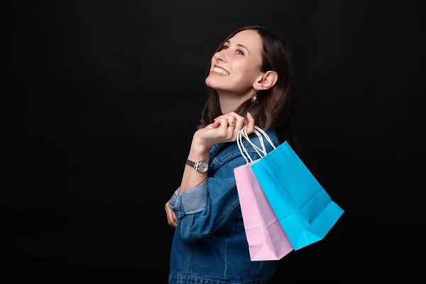 Porträt einer lächelnden Frau in lässiger Kleidung mit bunten Einkaufstaschen — Stockfoto