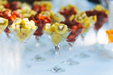 Bir düğün Bar için beyaz masada kokteyl gözlük dilimlenmiş kivi ve çilek.