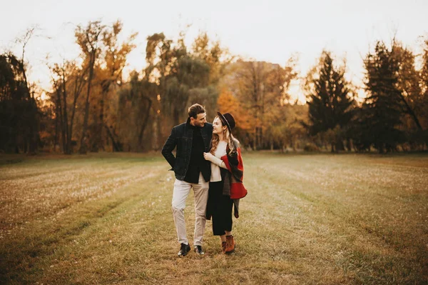 Alegre joven pareja enamorada de tener una cita en el parque al atardecer —  Fotos de Stock