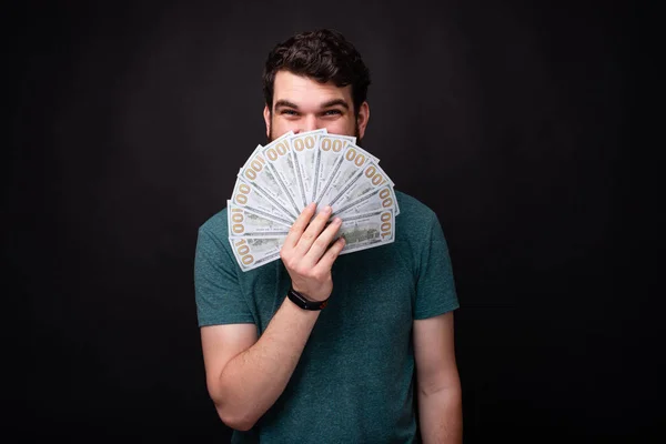 Photo of cheerful man covering his face with bunch of dollars — Stock Photo, Image