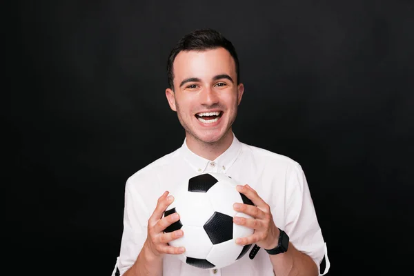 Ele apanhou a bola! Objetivo!!! Jovem animado homem segurando uma bola de futebol olhando para a câmera de perto . — Fotografia de Stock