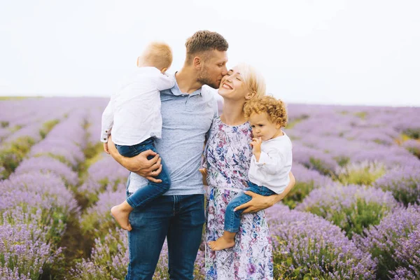 Happy young family are enjoying their time together in the middle os lavender field. — Stock Photo, Image