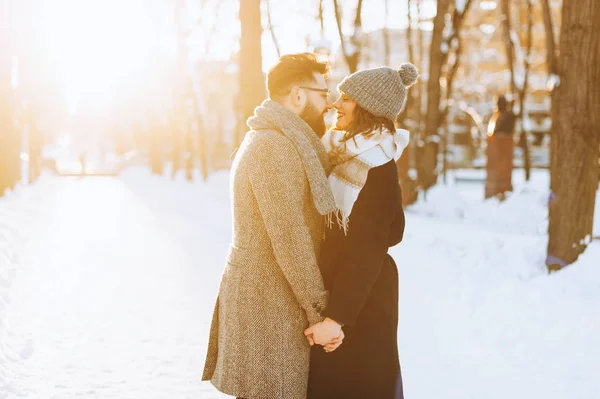 Junges glückliches Paar schaut einander an und genießt im Winter die gemeinsame Zeit im Park. — Stockfoto