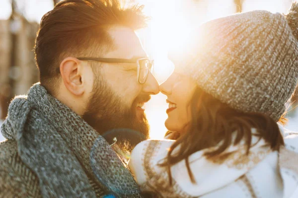 Jovem casal feliz olhando um para o outro e sorrindo no parque no inverno . — Fotografia de Stock