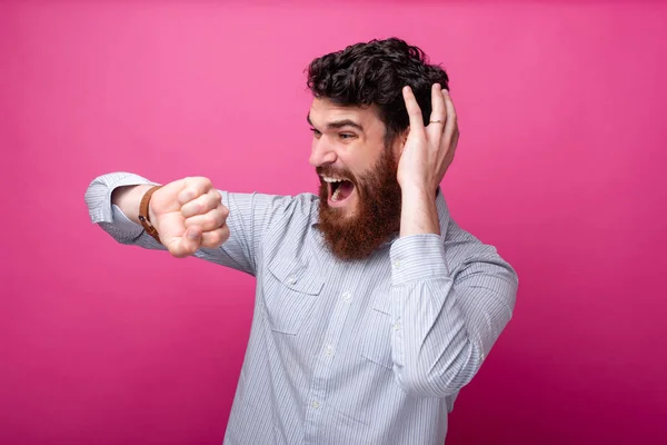 Shocked bearded man in casual looking at smart watch — Stock Photo, Image