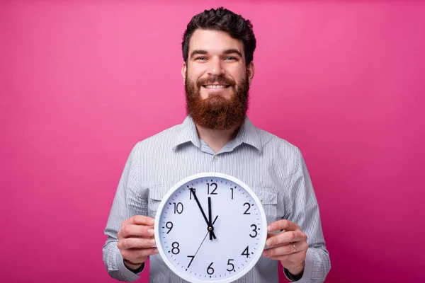Πορτρέτο του χαμογελαστή άντρα με γένια κρατώντας ένα μεγάλο λευκό ρολόι — Φωτογραφία Αρχείου