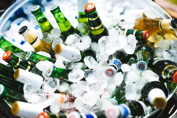 Unas botellas de cerveza en un tazón grande lleno de hielo. Bar de bodas al aire libre . — Foto de Stock