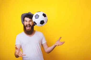 Gooaaaalllll !!! Heyecanlı sakallı adamın fotoğrafı, şapkayı bükme, top kusma ve kutlama, sarı arka plan üzerinde 