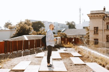 Çatıda duran ve bir yere bakan adam 