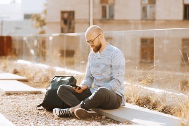 Açık akıllı telefon kullanarak sakallı neşeli gülümseyen adam