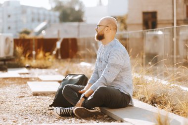 Sunligh açık havada oturan sakallı hipster adam Portresi