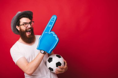 Sakallı taraftarın fotoğrafı, büyük parmak eldiveni ile, futbol topu tutan