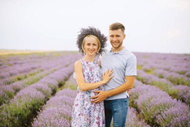 Handsoem güzel bir çift laveder alanında poz, gülümseyerek ve kamera bakarak 