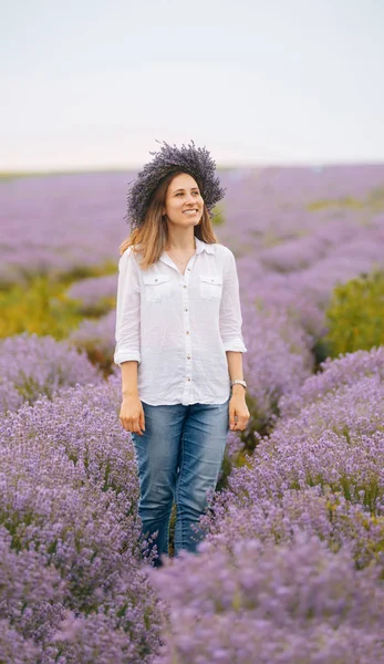 Başında çiçek çelenk ile lavanta alanında poz bir yung kadın portresi 