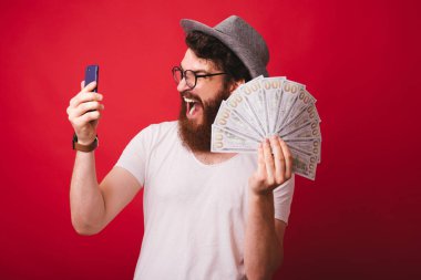 Yakışıklı heyecanlı sakallı adam bir şapka ve gözlük giyen, gösteren 