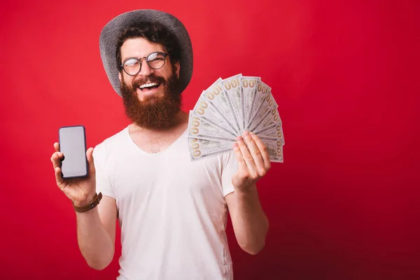 Photo of bearded man, wearing hat and glasses, showing at camera — Stock Photo, Image