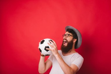 Kırmızı arka üzerinden futbol topu yakalamak neşeli hayran adam fotoğrafı