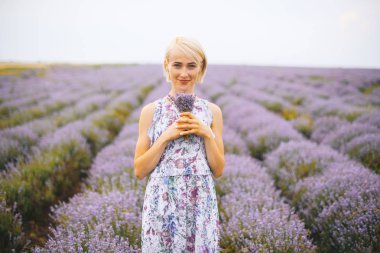 Lavanta Tarlası ortasında Lavanta bir buket tutan genç kadın.