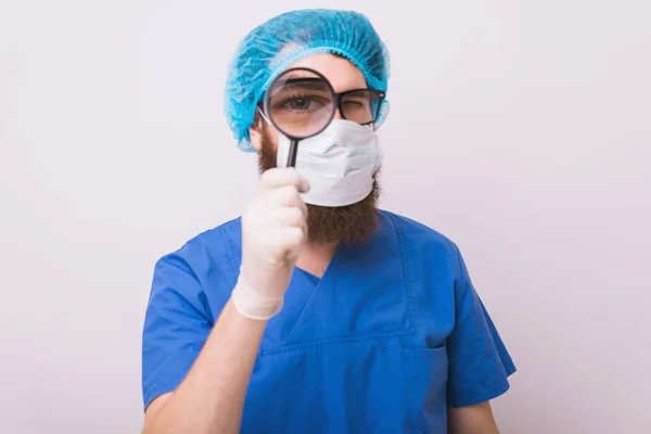 Medico chirurgo con maschera e lente d'ingrandimento fare investigati — Foto Stock
