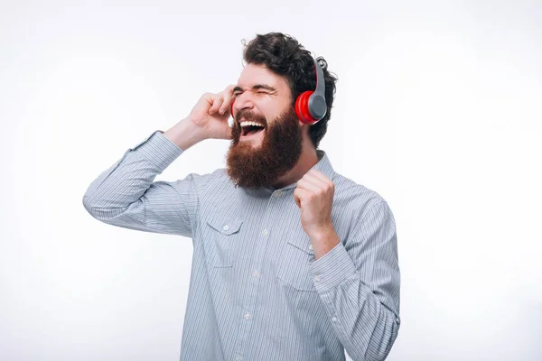 Foto de hombre barbudo feliz emocionado en casual escuchando su favou —  Fotos de Stock