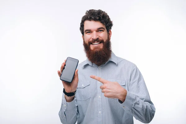 Photo de l'homme barbu pointant vers l'écran du smartphone — Photo