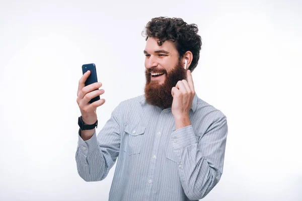 Фото веселого человека с бородой в случайном взгляде на смартфон — стоковое фото