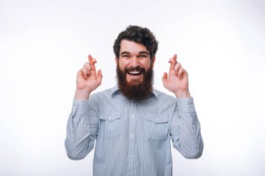 Beyaz üzerinde ayakta çapraz parmaklar ile gülümseyen adam portresi