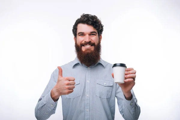Portrait of satisfied man in casual holding cup of coffee to go