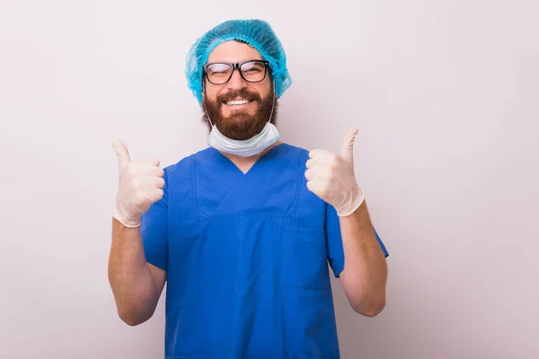 Foto di felice sorridente medico mostrando pollici sopra la schiena bianca — Foto Stock