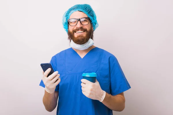 Foto di un medico sorridente che prende il suo caffè mattutino e tiene il sm — Foto Stock