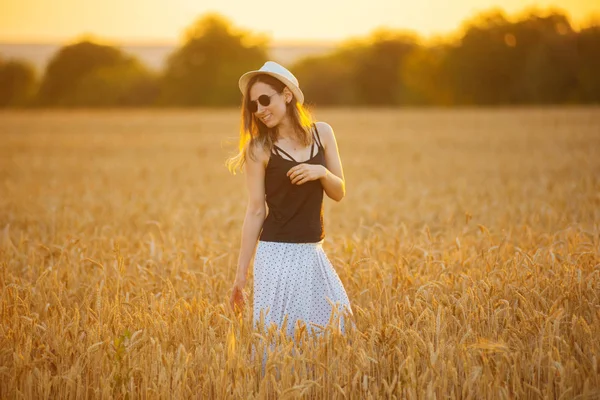 Foto einer hübschen jungen Frau, die in einem Weizenfeld spaziert, — Stockfoto