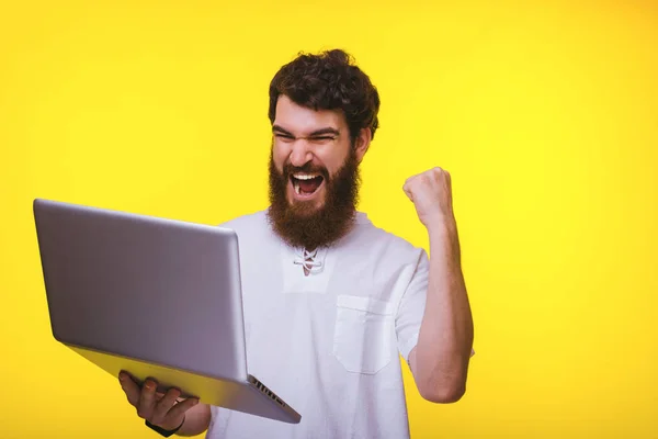 Photo de jeune homme émerveillé célébrant le succès et regardant son — Photo