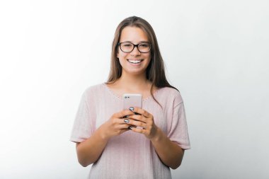 Akıllı telefon tutan ve kameraya bakarak büyüleyici genç kadın Portresi, Blogger bir makale göndermek için hazır 