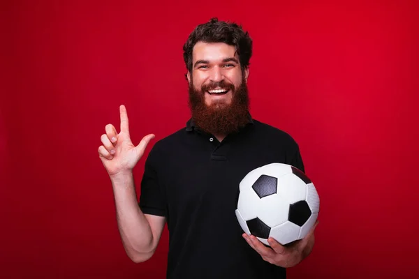 Foto eines gut aussehenden Unterstützers, der einen Fußballball in der Hand hält, während — Stockfoto