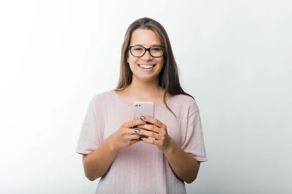 Retrato de la encantadora mujer joven sosteniendo el teléfono inteligente y mirando a la cámara, Blogger listo para publicar un artículo — Foto de Stock