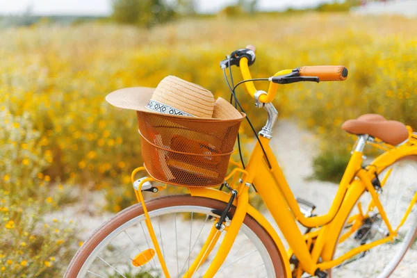 Concepto de viaje vintage. Foto de una bicicleta amarilla con sombrero en ba — Foto de Stock